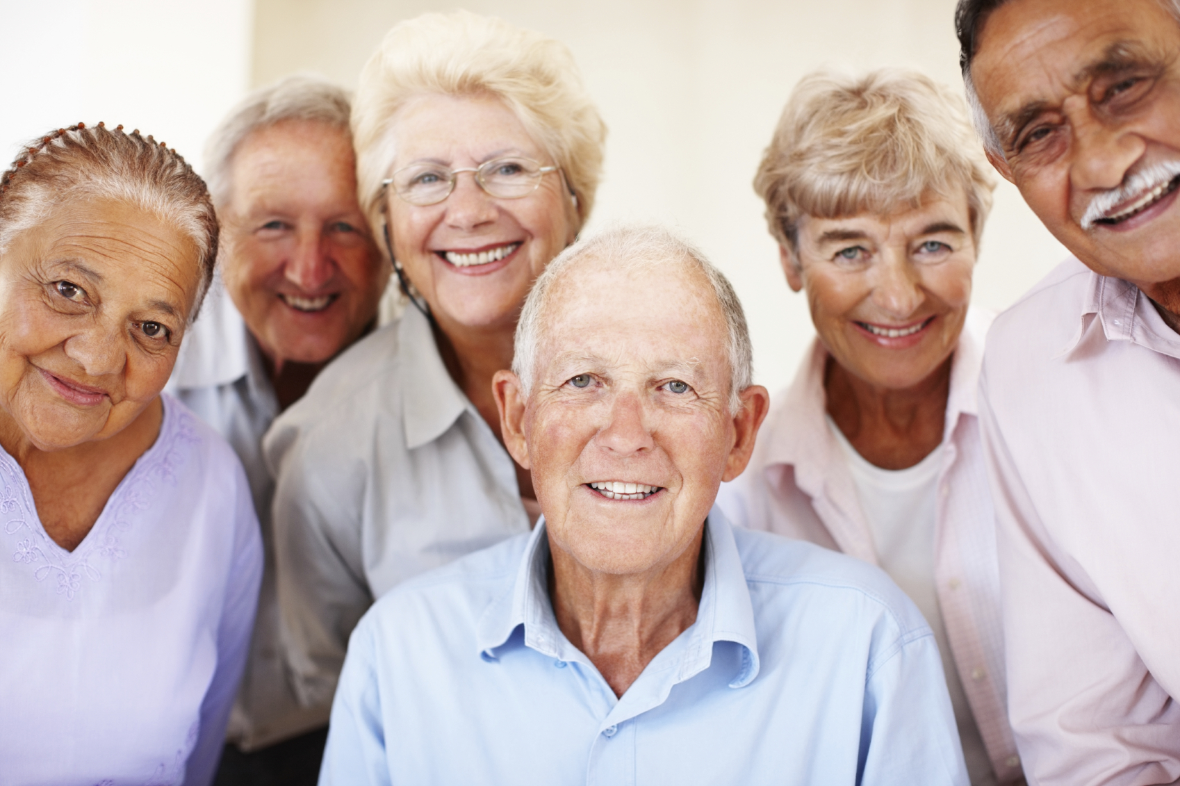 Group of six joyful elderly friends smiling together