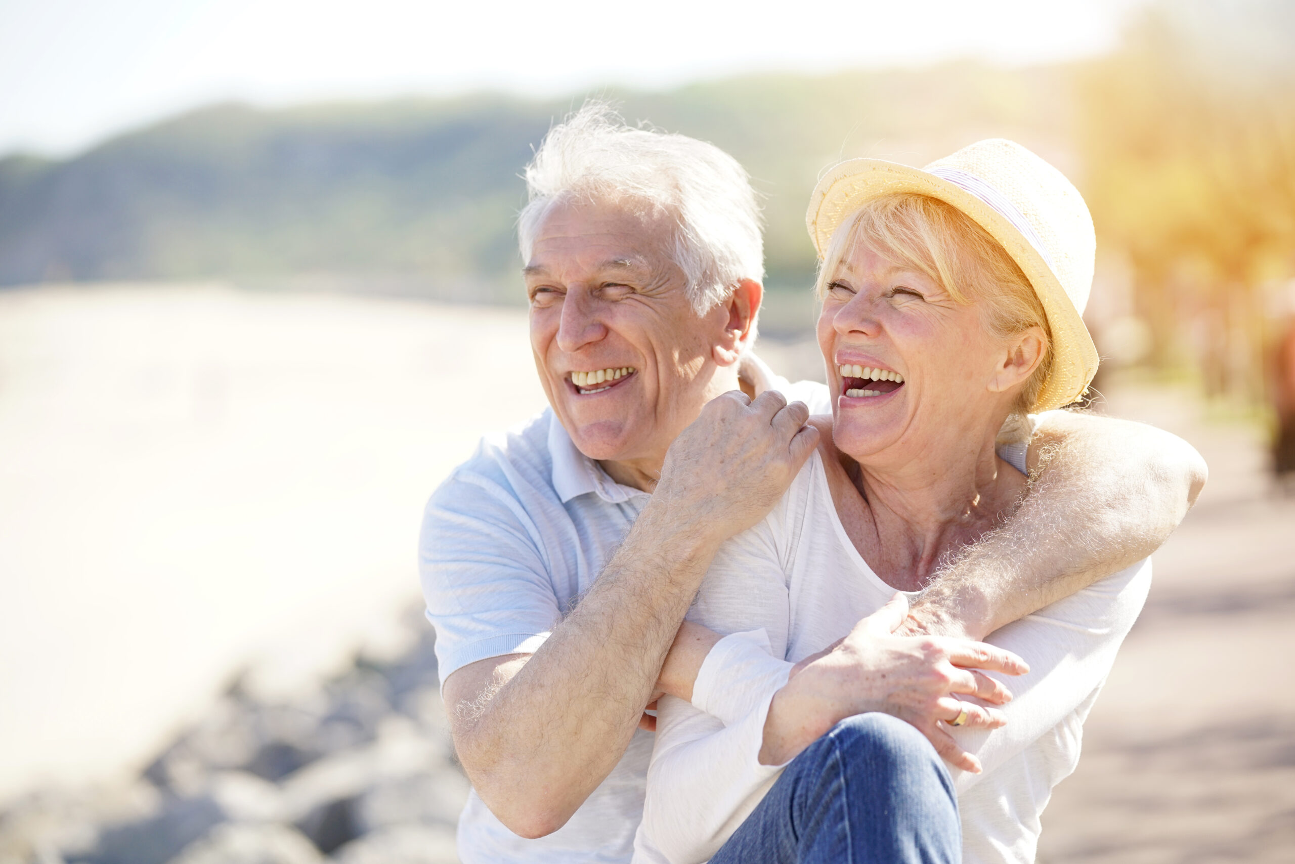 Elderly couple embracing each other lovingly on a serene beach